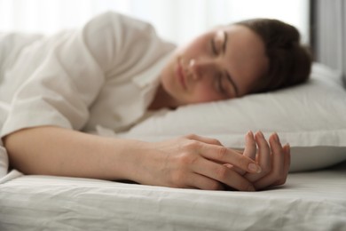 Photo of Young woman sleeping on bed at home, selective focus