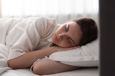 Photo of Young woman sleeping on bed at home