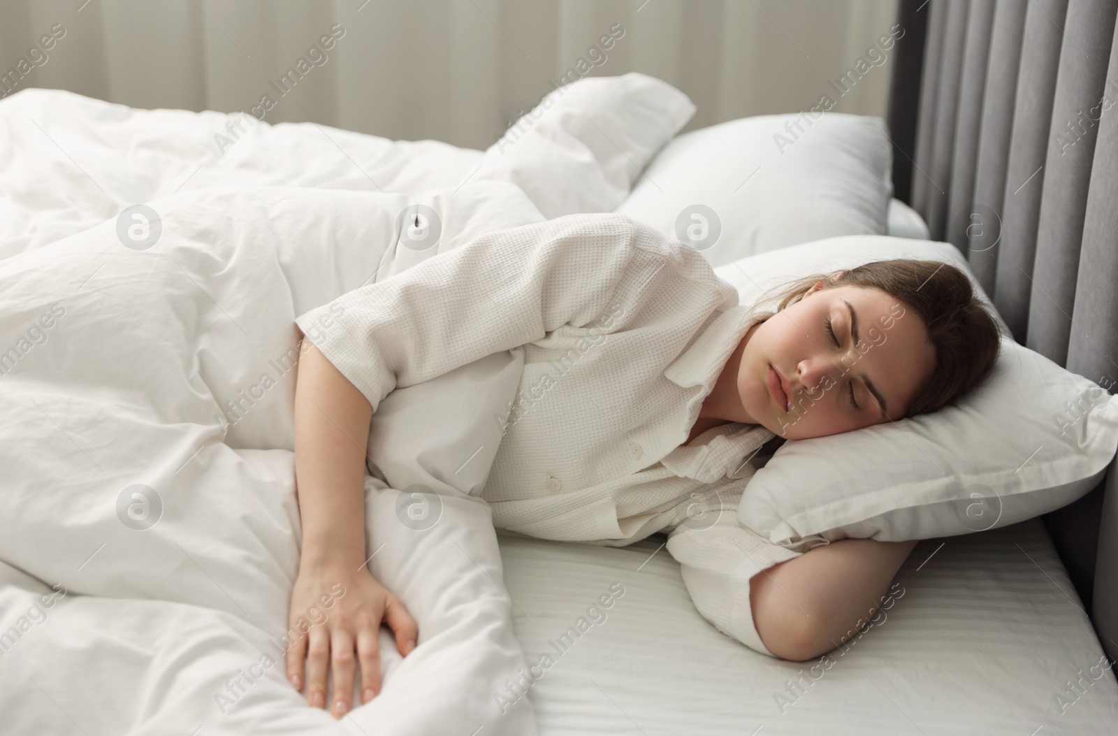 Young woman sleeping on bed at home Photo of Young woman sleeping on bed at home
