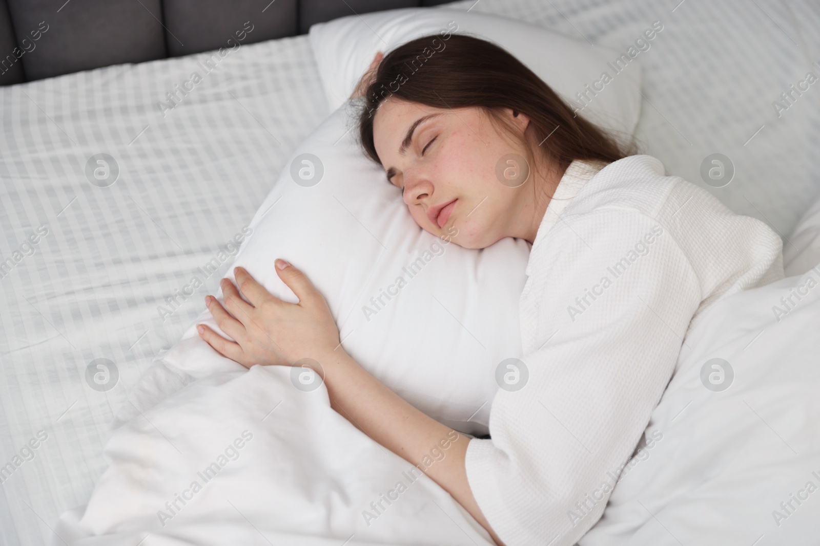 Young woman sleeping on bed at home Photo of Young woman sleeping on bed at home