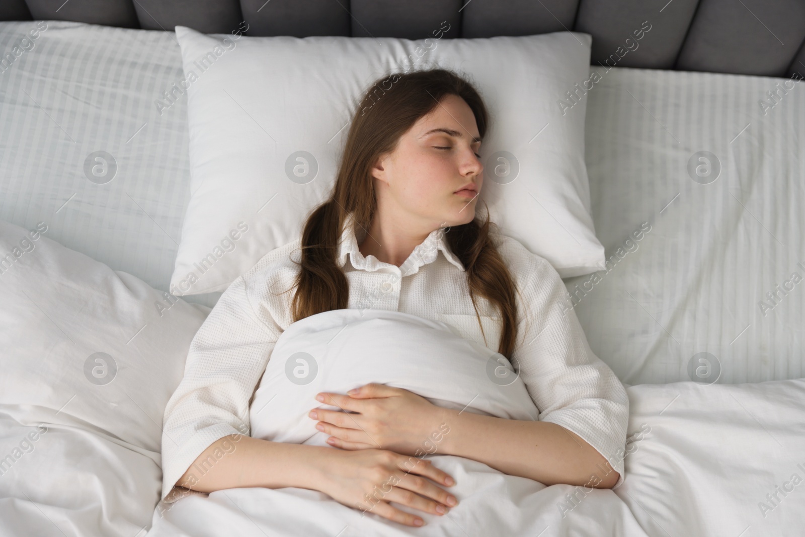 Young woman sleeping on bed at home, above view Photo of Young woman sleeping on bed at home, above view
