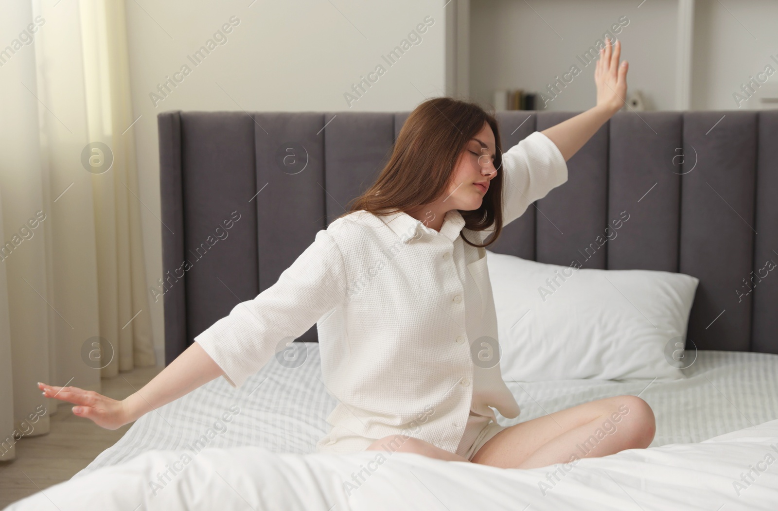 Young woman stretching on bed at home Photo of Young woman stretching on bed at home