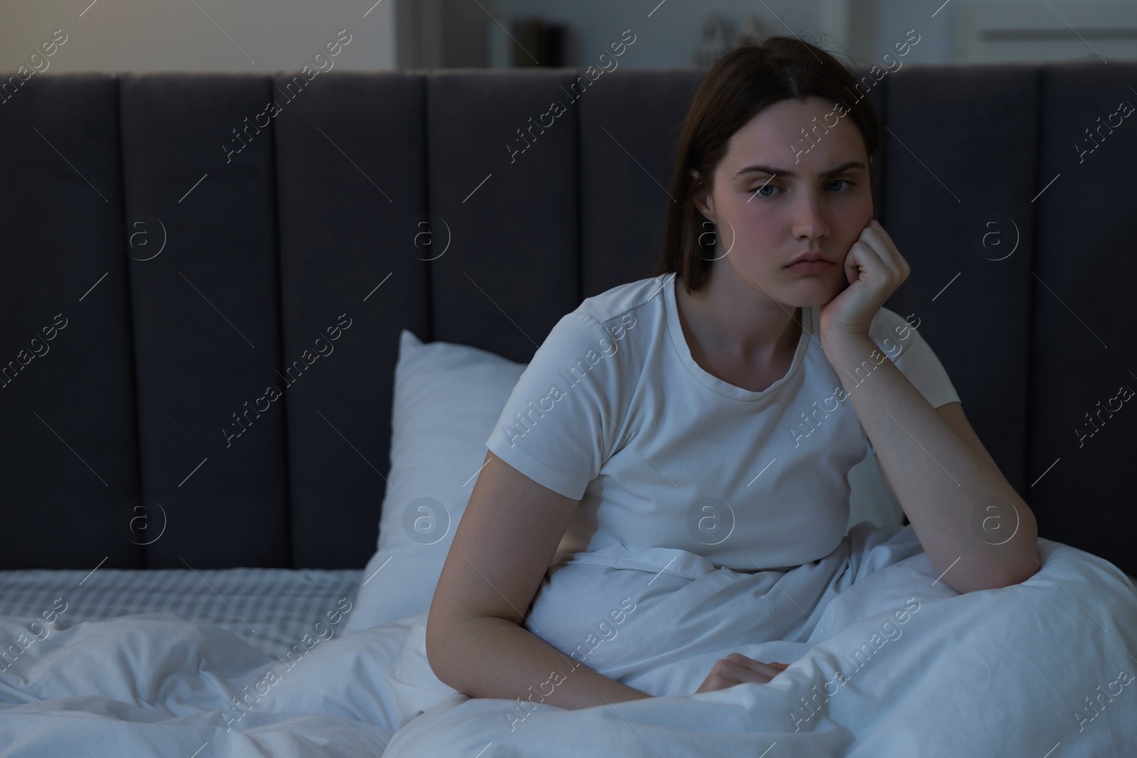 Frustrated young woman suffering from insomnia on bed indoors Photo of Frustrated young woman suffering from insomnia on bed indoors