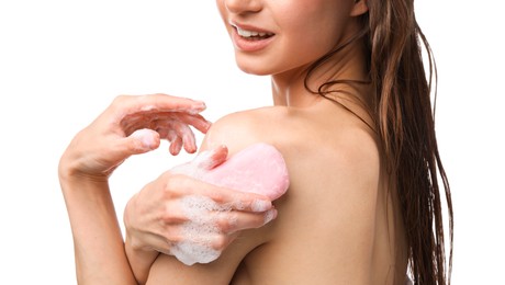 Photo of Smiling woman washing body with soap bar on white background, closeup