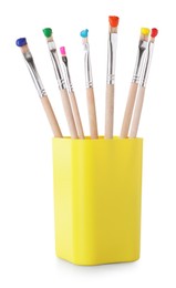 Photo of Brushes with color paints in cup isolated on white