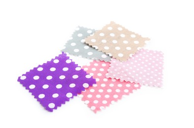 Photo of Samples of fabrics with polka dot pattern isolated on white