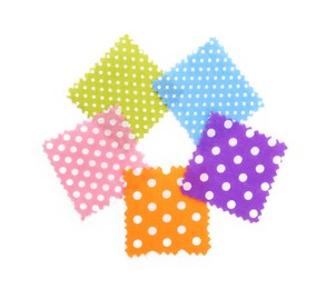 Photo of Samples of fabrics with polka dot pattern isolated on white, top view