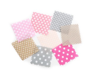 Photo of Samples of fabrics with polka dot pattern isolated on white, top view