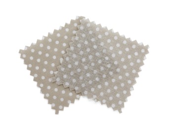 Photo of Samples of fabrics with polka dot pattern isolated on white, top view