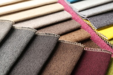 Photo of Samples of different fabrics as background, closeup