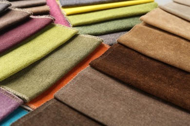 Photo of Samples of different fabrics as background, closeup