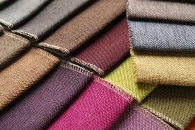 Photo of Samples of different fabrics as background, closeup