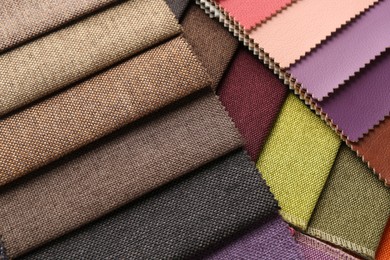 Photo of Samples of different fabrics as background, closeup