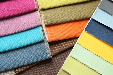 Photo of Samples of different fabrics as background, closeup