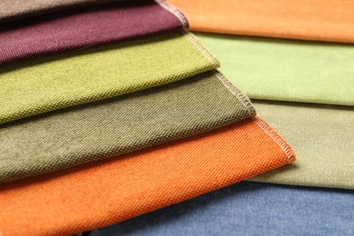 Photo of Samples of different fabrics as background, closeup