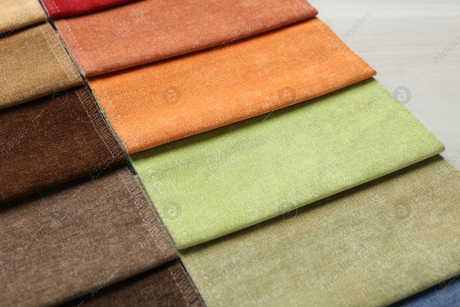Samples of different fabrics on light wooden table, closeup Photo of Samples of different fabrics on light wooden table, closeup