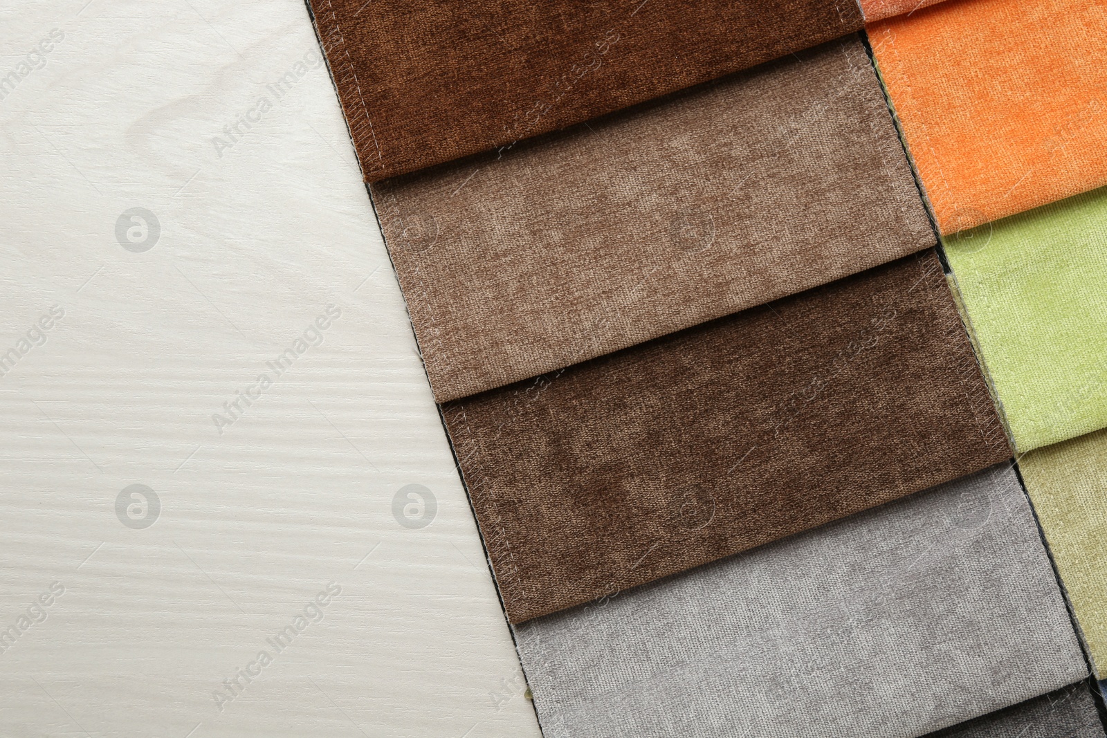 Samples of different fabrics on light wooden table, top view. Space for text Photo of Samples of different fabrics on light wooden table, top view. Space for text