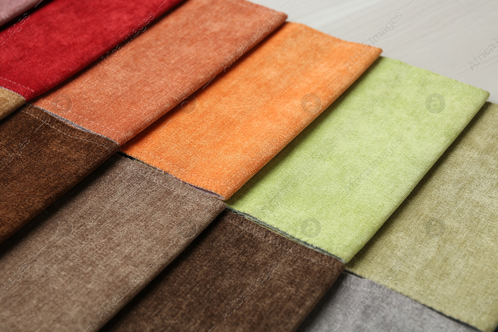 Samples of different fabrics on light wooden table, closeup Photo of Samples of different fabrics on light wooden table, closeup