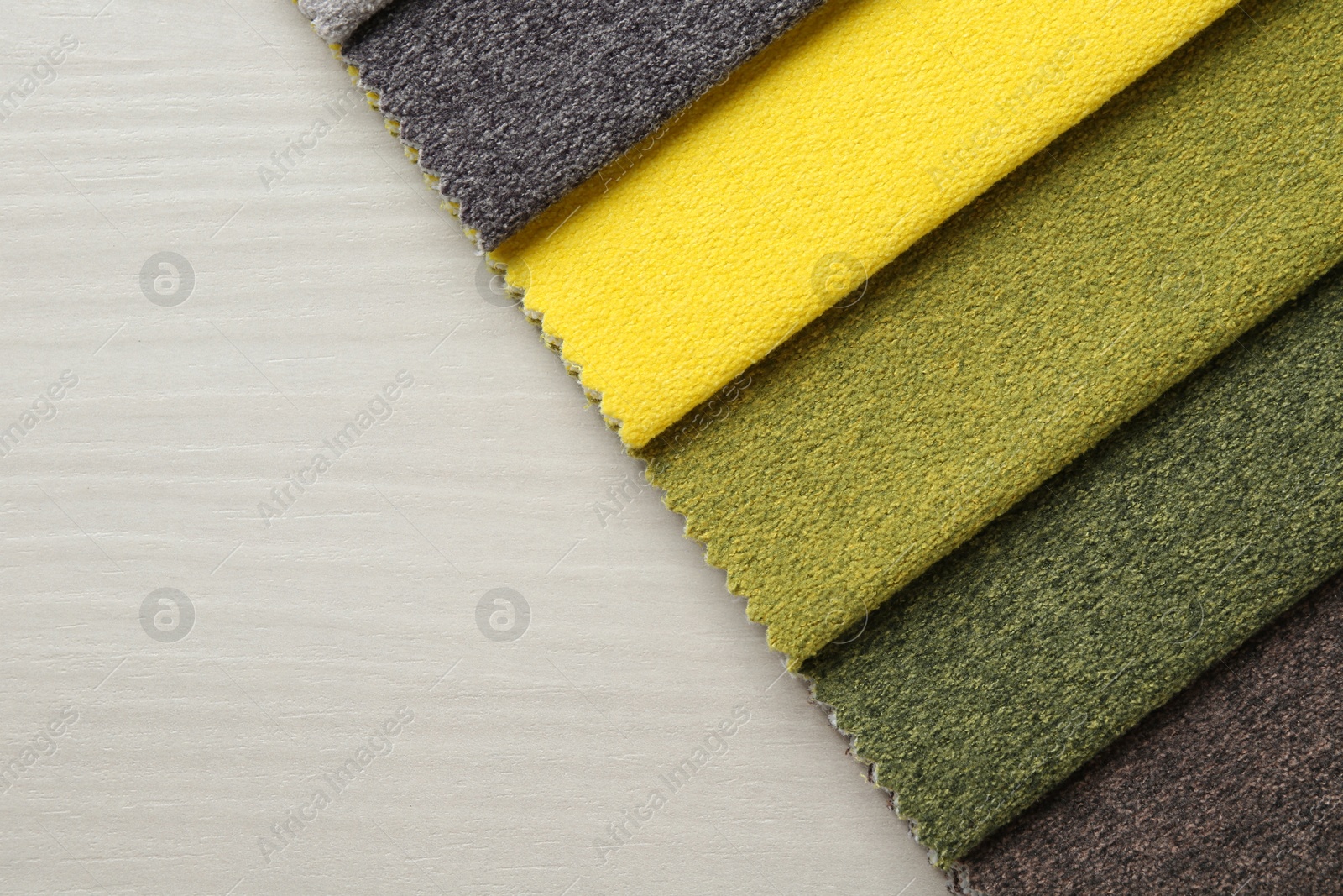 Samples of different fabrics on light wooden table, top view. Space for text Photo of Samples of different fabrics on light wooden table, top view. Space for text