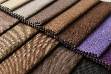 Photo of Samples of different fabrics as background, closeup