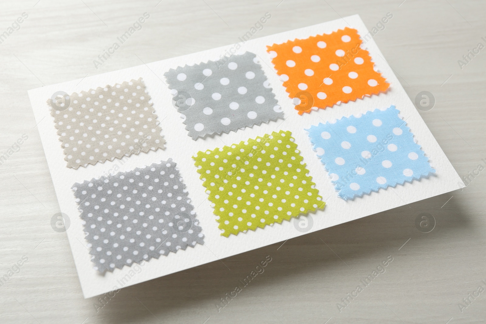 Samples of fabrics with polka dot pattern on light wooden table Photo of Samples of fabrics with polka dot pattern on light wooden table