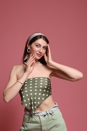Photo of Fashionable portrait of beautiful woman in stylish outfit on pink background