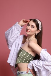 Photo of Fashionable portrait of beautiful woman in stylish outfit on pink background