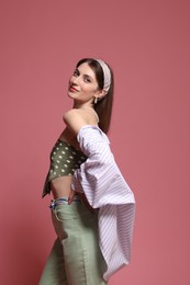 Photo of Fashionable portrait of beautiful woman in stylish outfit on pink background