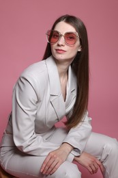 Photo of Fashionable portrait of beautiful woman in stylish outfit on pink background