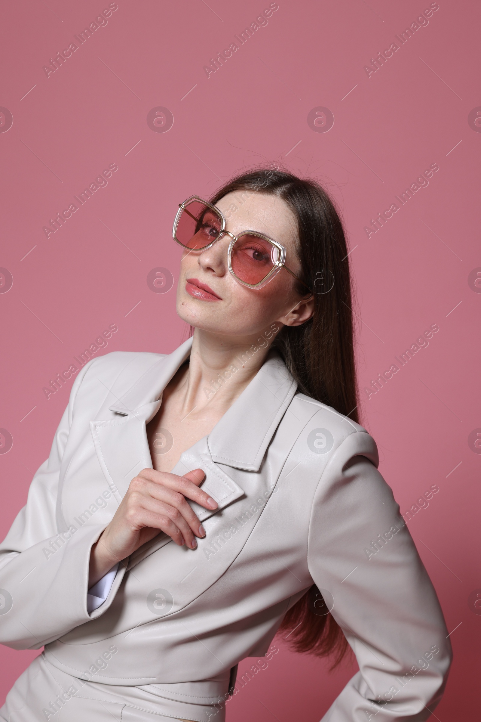 Fashionable portrait of beautiful woman in stylish outfit on pink background Photo of Fashionable portrait of beautiful woman in stylish outfit on pink background