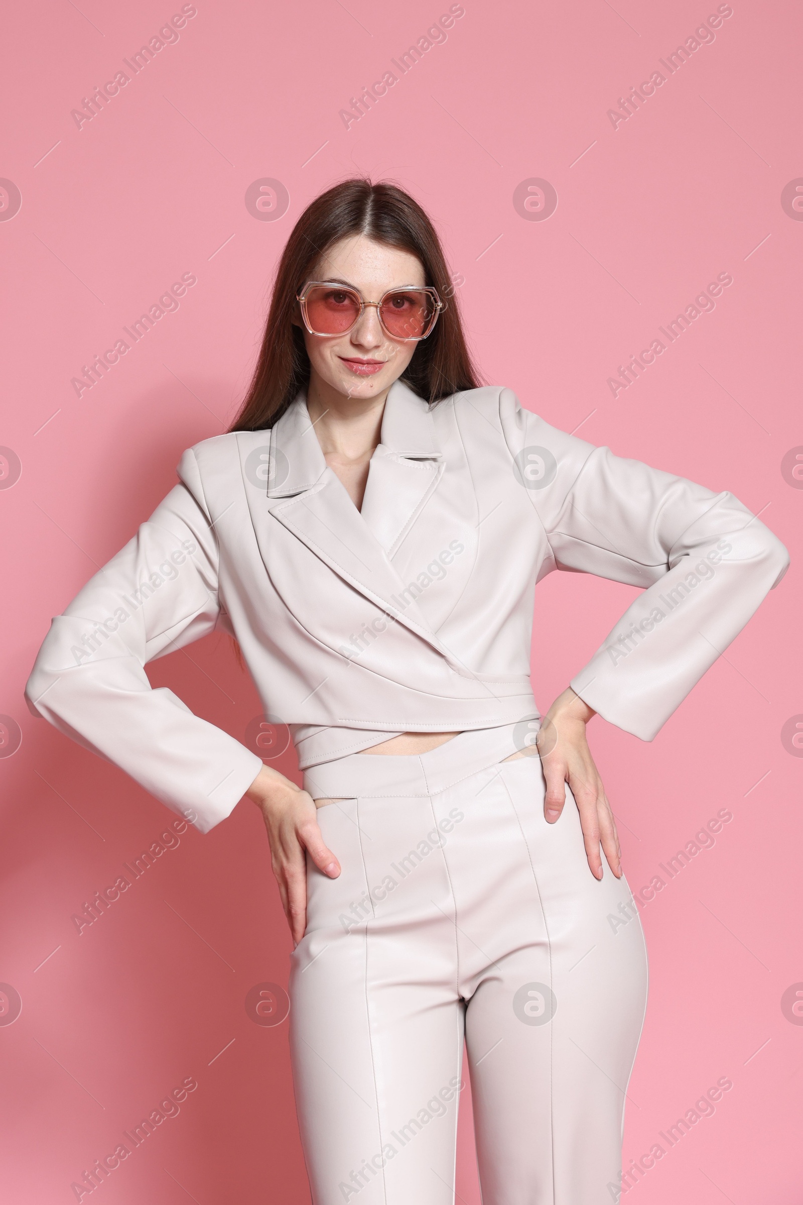 Fashionable portrait of beautiful woman in stylish outfit on pink background Photo of Fashionable portrait of beautiful woman in stylish outfit on pink background