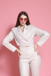 Photo of Fashionable portrait of beautiful woman in stylish outfit on pink background