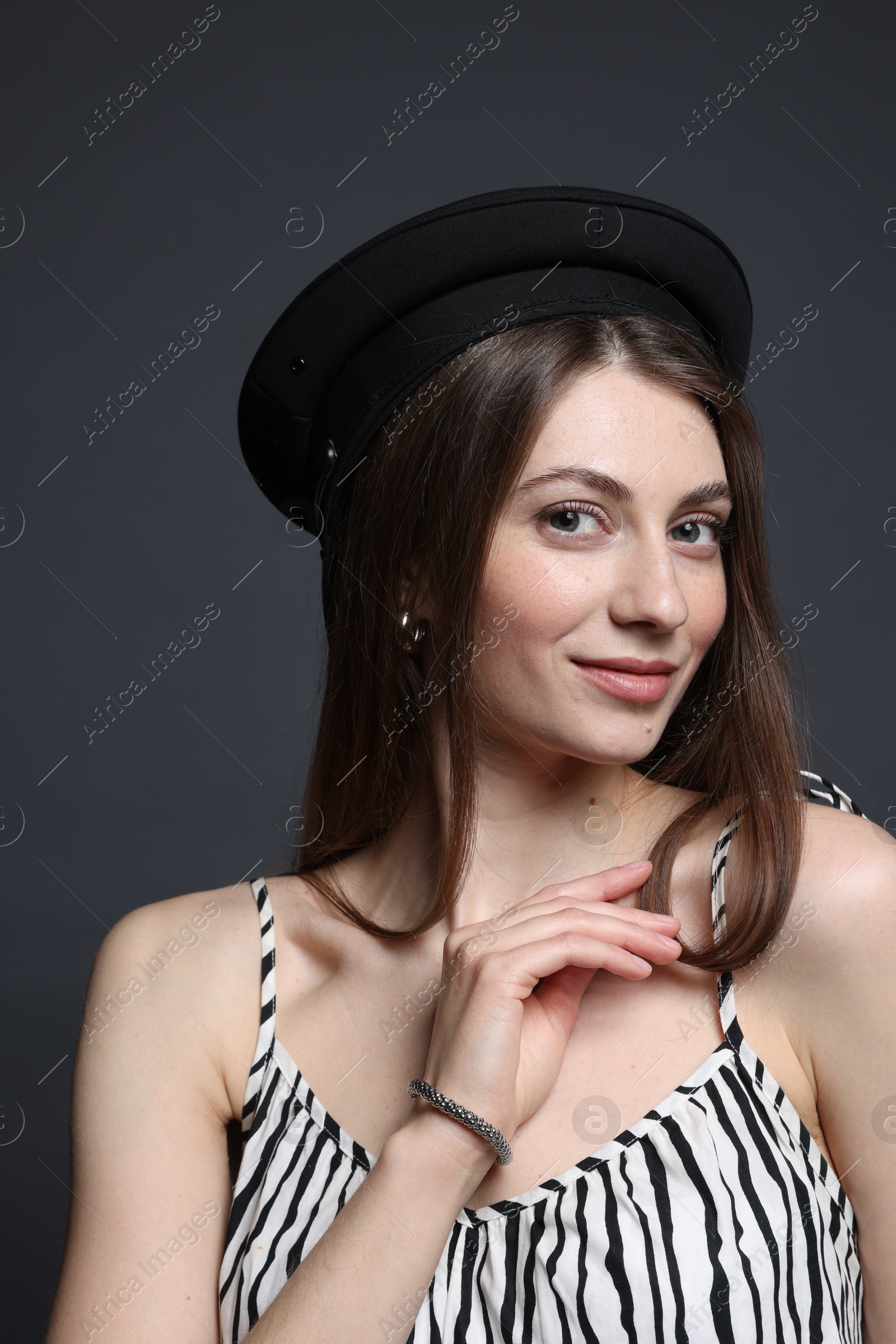 Fashionable portrait of beautiful woman in stylish outfit on grey background Photo of Fashionable portrait of beautiful woman in stylish outfit on grey background