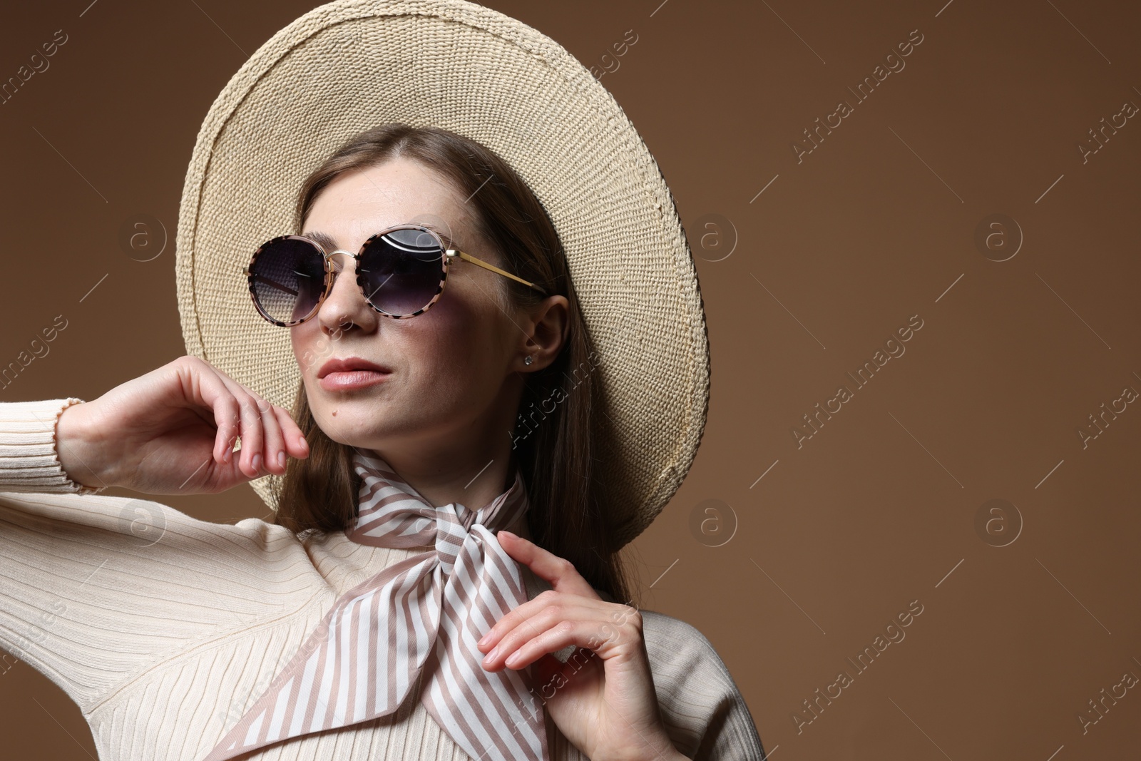 Fashionable portrait of beautiful woman in stylish outfit on brown background. Space for text Photo of Fashionable portrait of beautiful woman in stylish outfit on brown background. Space for text