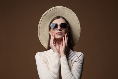 Photo of Fashionable portrait of beautiful woman in stylish outfit on brown background