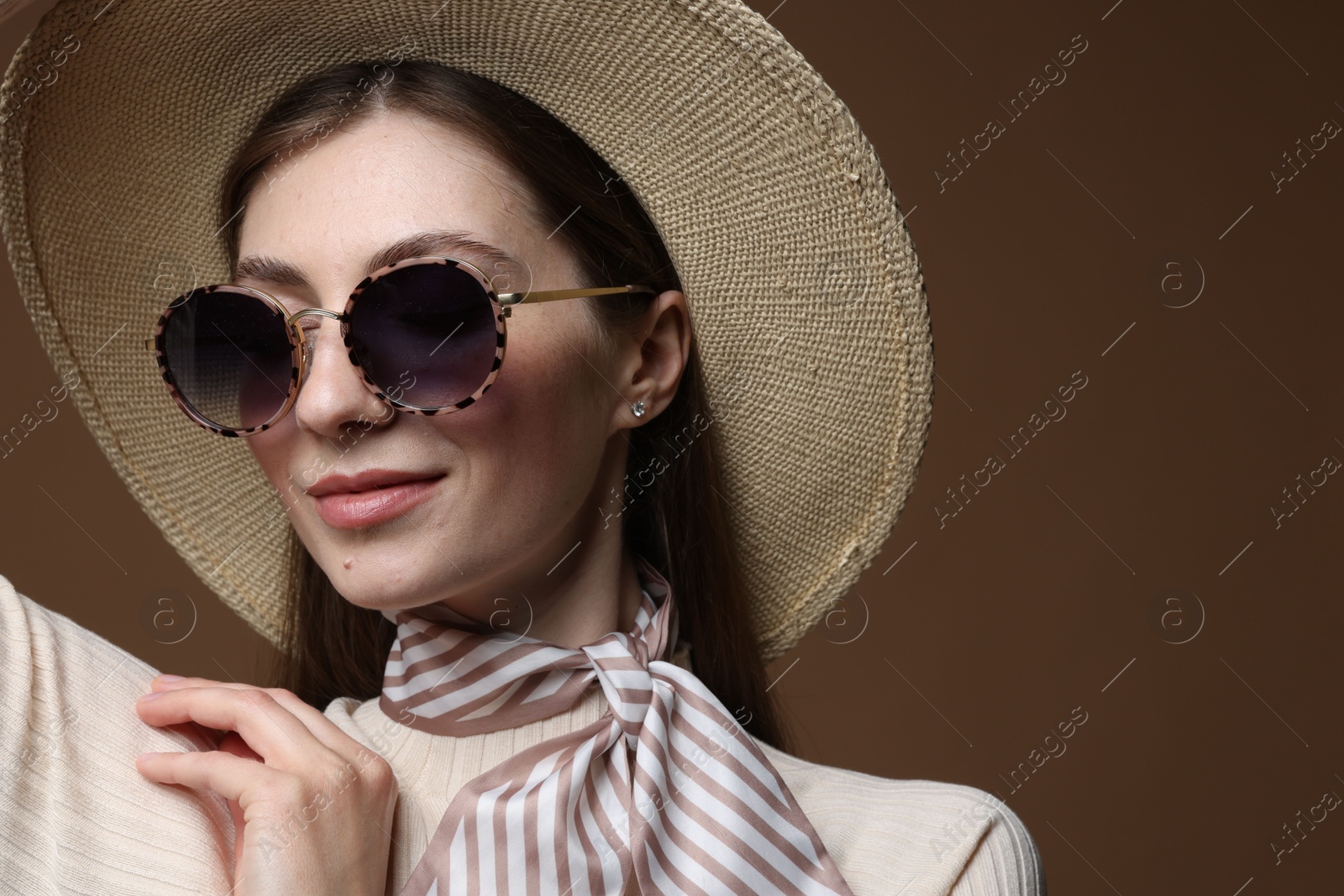 Fashionable portrait of beautiful woman in stylish outfit on brown background Photo of Fashionable portrait of beautiful woman in stylish outfit on brown background
