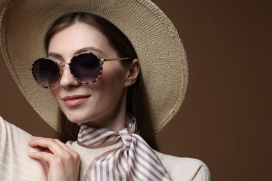 Photo of Fashionable portrait of beautiful woman in stylish outfit on brown background