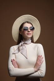 Photo of Fashionable portrait of beautiful woman in stylish outfit on brown background