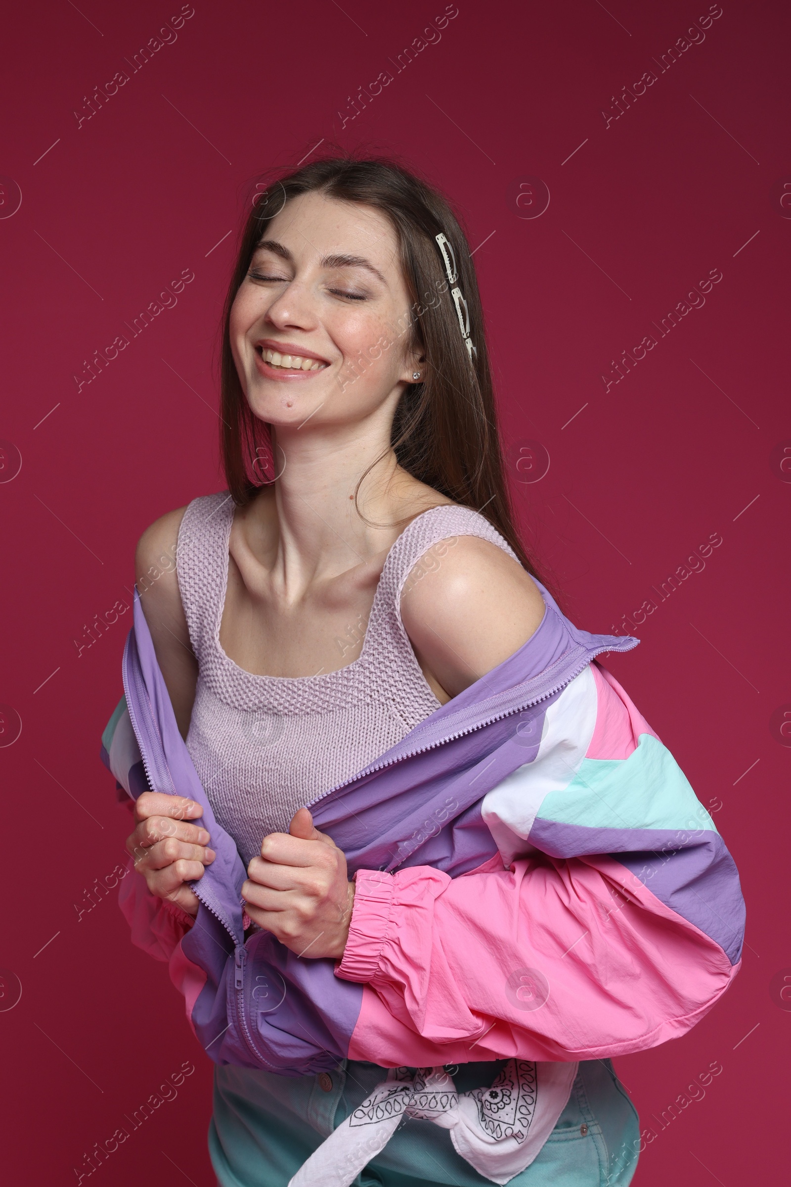 Fashionable portrait of beautiful woman in stylish outfit on crimson background Photo of Fashionable portrait of beautiful woman in stylish outfit on crimson background