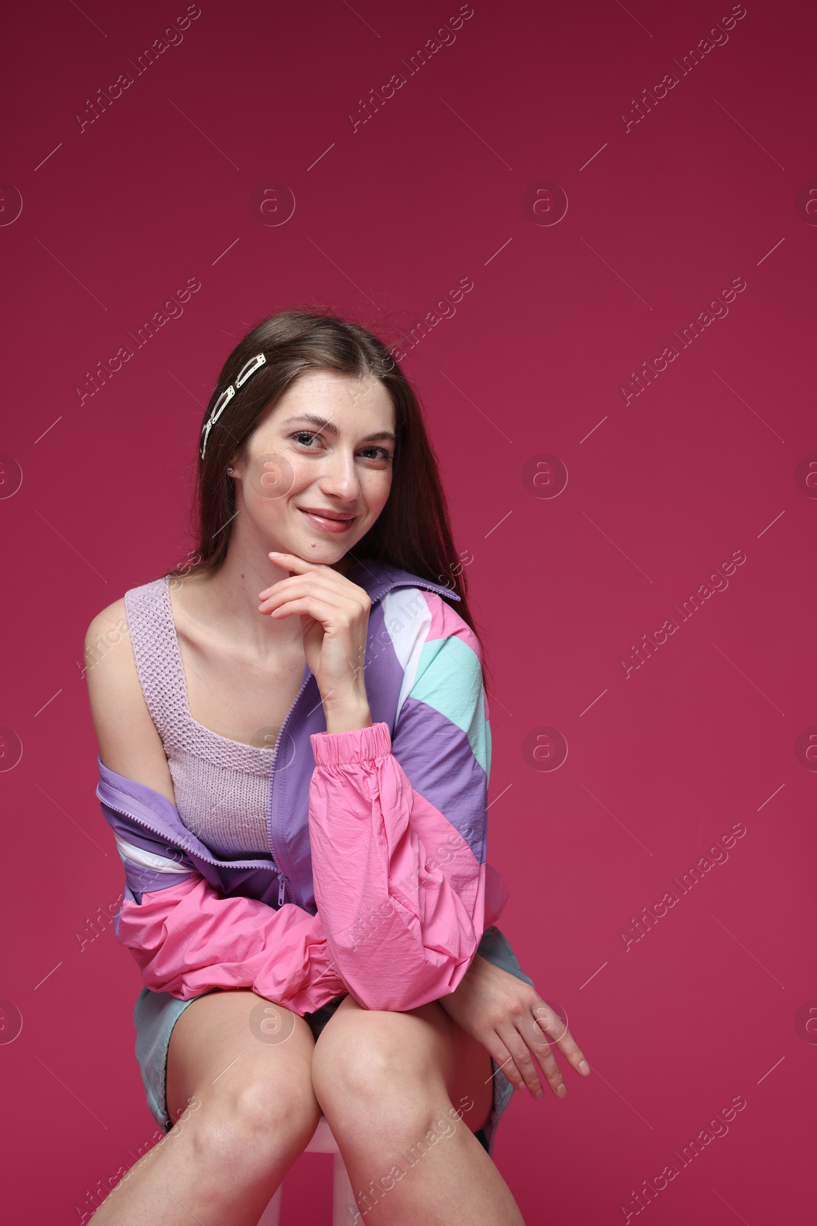 Fashionable portrait of beautiful woman in stylish outfit on crimson background Photo of Fashionable portrait of beautiful woman in stylish outfit on crimson background