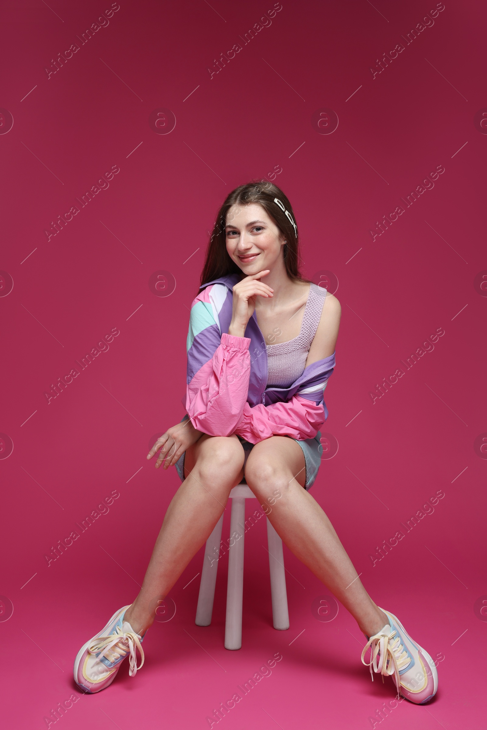 Fashionable portrait of beautiful woman in stylish outfit on crimson background Photo of Fashionable portrait of beautiful woman in stylish outfit on crimson background