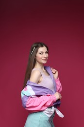 Photo of Fashionable portrait of beautiful woman in stylish outfit on crimson background