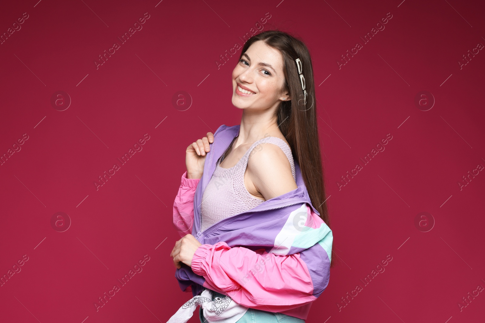 Fashionable portrait of beautiful woman in stylish outfit on crimson background Photo of Fashionable portrait of beautiful woman in stylish outfit on crimson background
