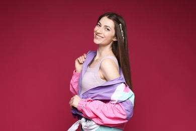 Photo of Fashionable portrait of beautiful woman in stylish outfit on crimson background