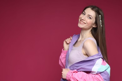 Photo of Fashionable portrait of beautiful woman in stylish outfit on crimson background. Space for text