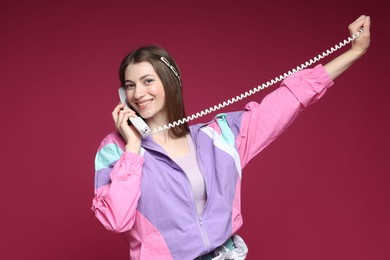 Photo of Fashionable portrait of beautiful woman in stylish outfit on crimson background