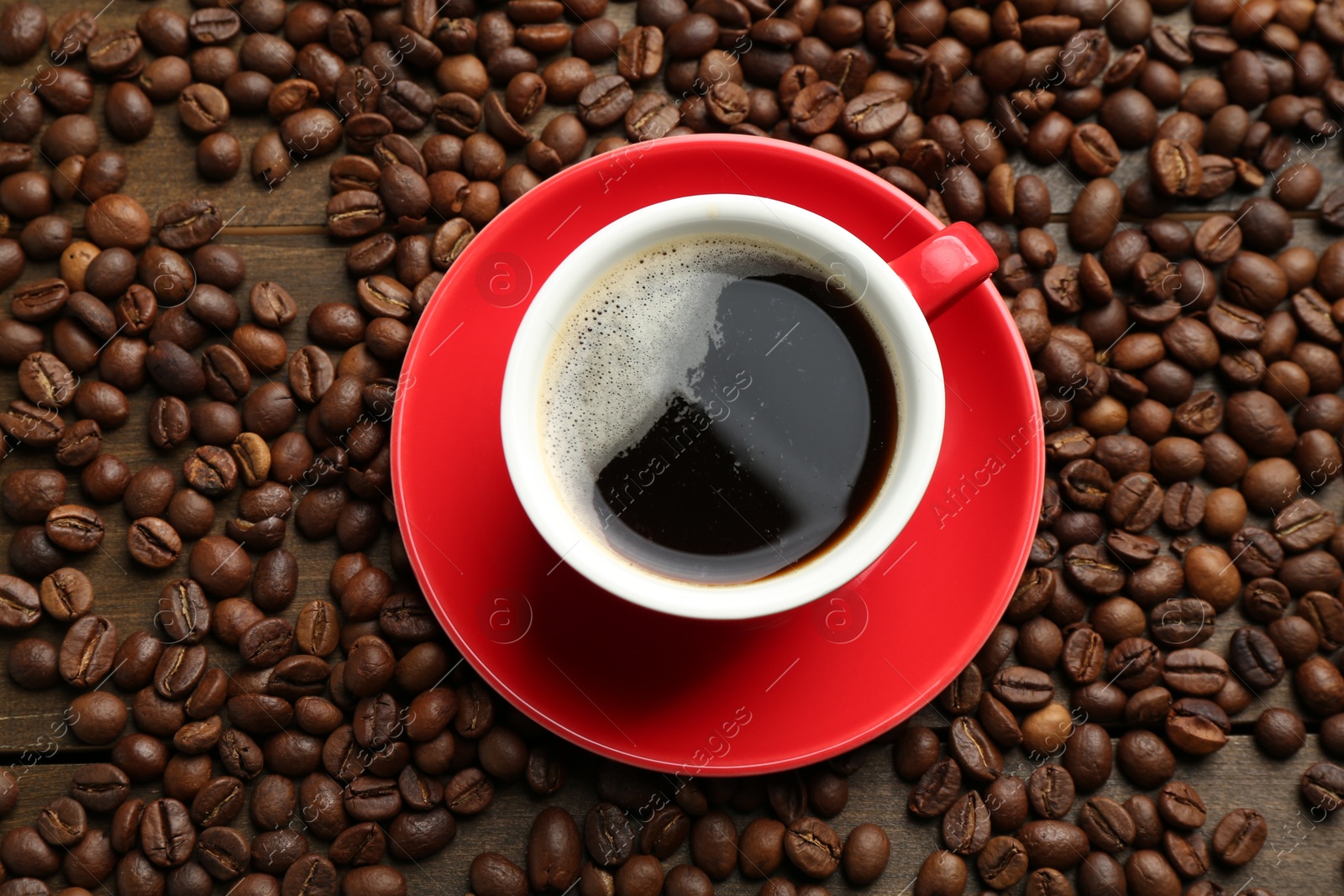 Aromatic coffee in cup and beans on wooden table, flat lay Photo of Aromatic coffee in cup and beans on wooden table, flat lay
