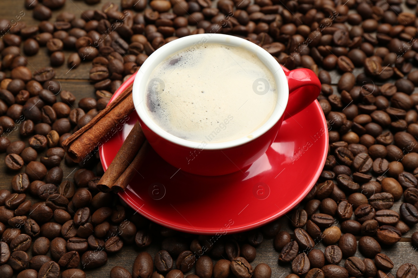 Aromatic coffee in cup, beans and cinnamon on table, above view Photo of Aromatic coffee in cup, beans and cinnamon on table, above view