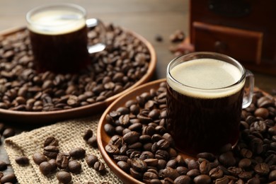 Photo of Aromatic coffee in cups and beans on table, closeup