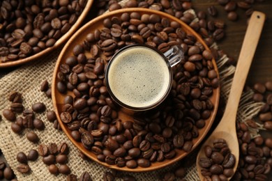 Photo of Aromatic coffee in cup and beans on table, flat lay